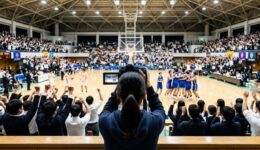 満員の観客が沸く試合の決定的瞬間を、観客席から撮影している後ろ姿